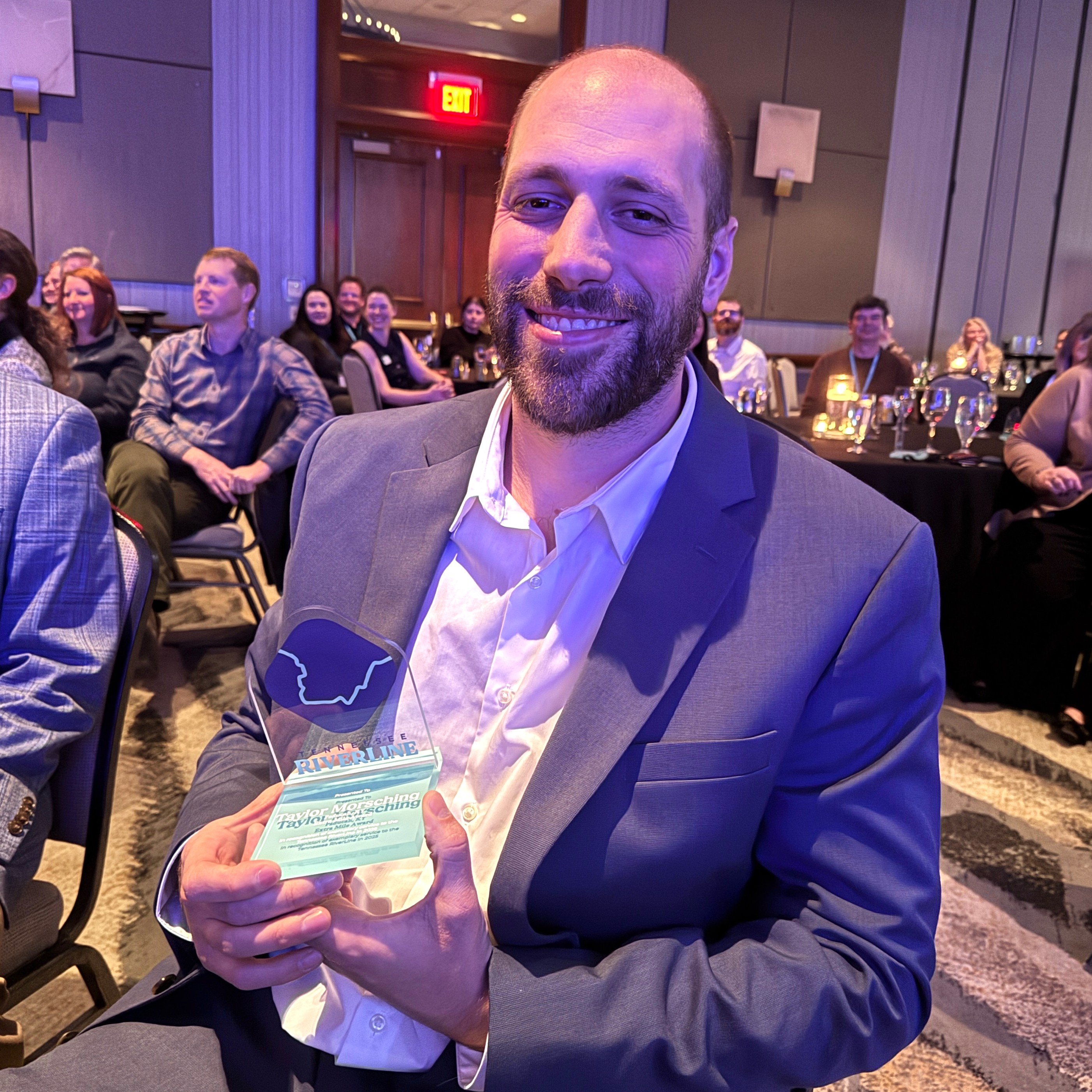 Taylor Morsching holding the award at the awards banquet.